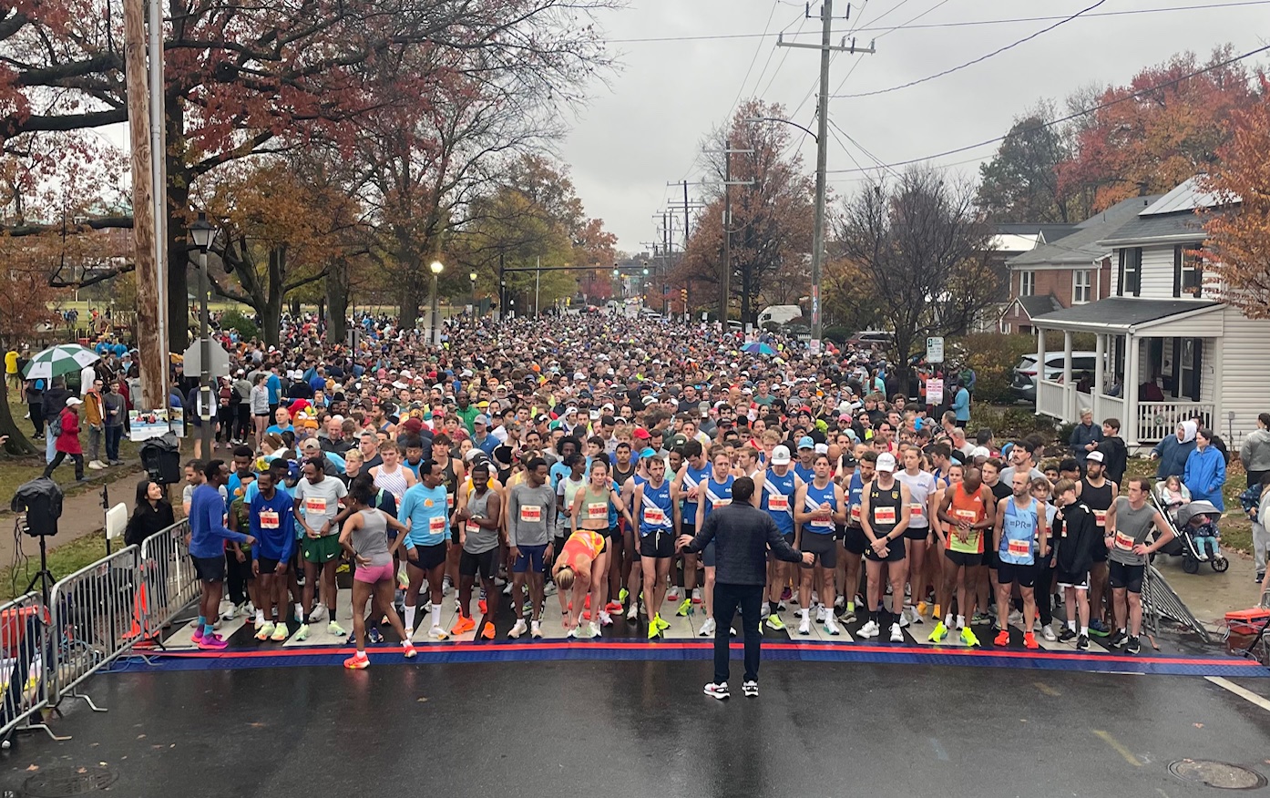 A large group of runners standing behind the start line of the 2024 Alexandria Turkey Trot