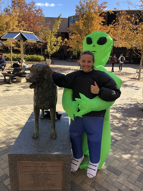 Anna Staats wearing what could be a green extraterrestrial costume but yet could also be a real extraterrestrial that is trying to abduct her