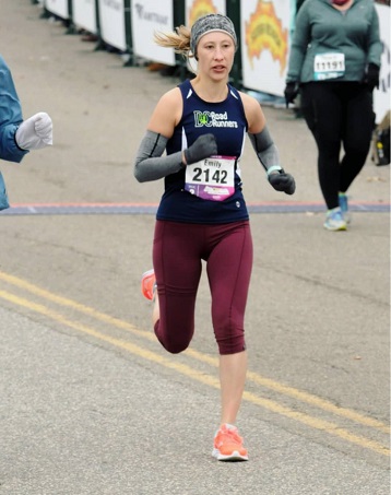 Emily Riley running in a road race wearing a blue DC Road Runners singlet
