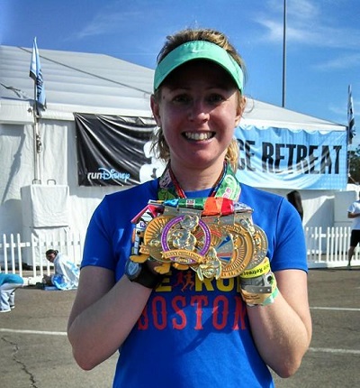 Kelly Fisher holding six Disney medals from the inaugural Dopey Challenge in 2014