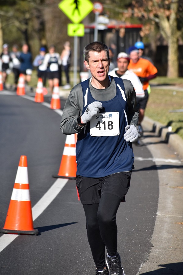 Ted Logothetti running in the Club Challenge 10 Miler while wearing a navy blue DC Road Runners singlet