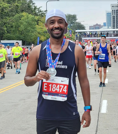 Yared Addisu holding a finisher medal at the Chicago Marathon