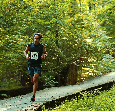 Ze Dagher racing on a wooden footbridge on a wooded trail