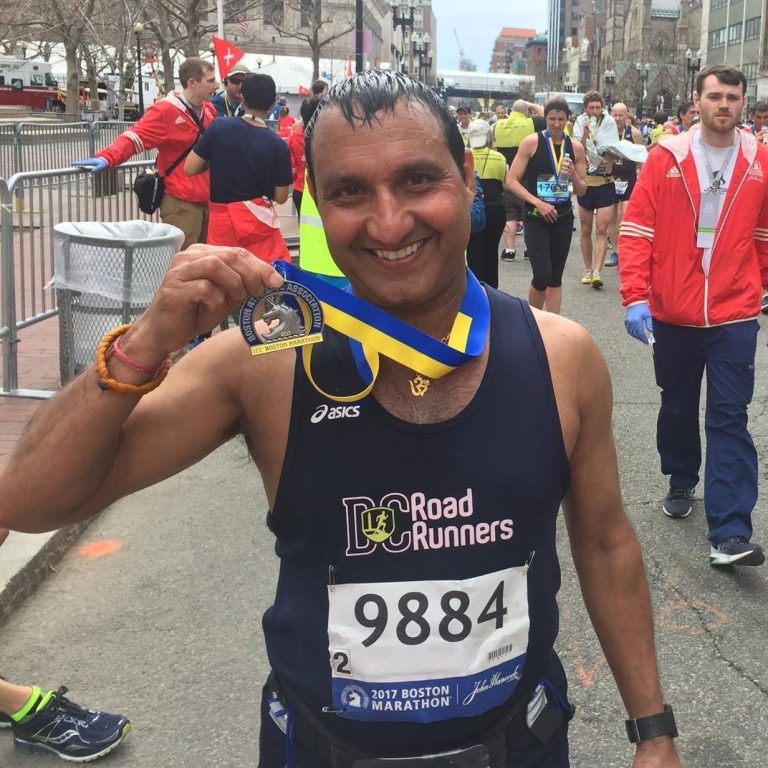 Raj Bhanot, Director for Contract Races, holding his medal after finishing the 2017 Boston Marathon