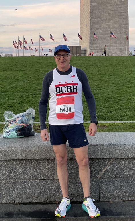 William Wheeler standing in front of the Washington Monument on a sunny spring morning at the Cherry Blossom Ten Miler