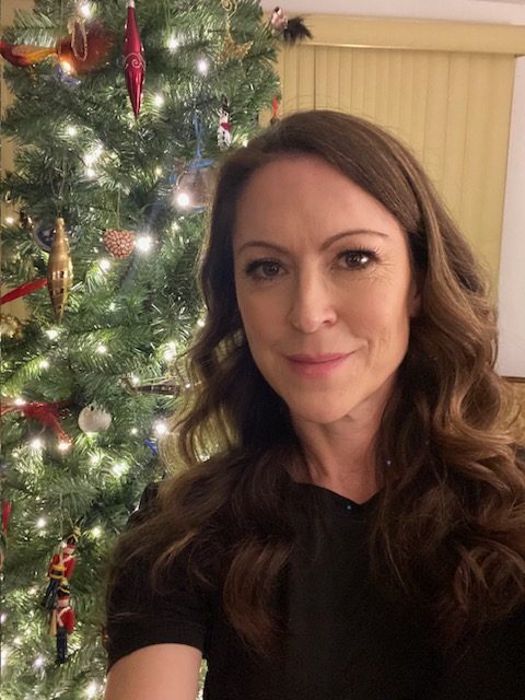 Courtney Kirkman standing in front of a nicely decorated Christmas tree
